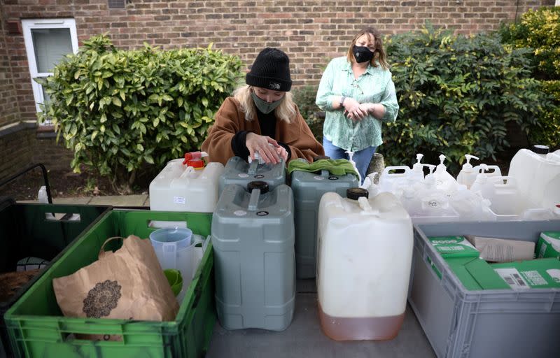 Ella Shone, serves a customer from her mobile zero waste shop called the 'Top Up Truck' in London