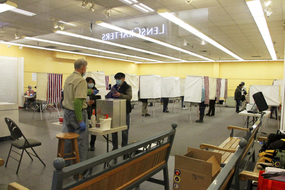 Residents in Anchorage, Alaska, take part in early voting in a mall in Alaska's largest city on Friday, Oct. 30, 2020. Alaska residents living in Juneau, Anchorage, Wasilla, Fairbanks and Nome can cast their votes early as designated locations. (AP Photo/Mark Thiessen)