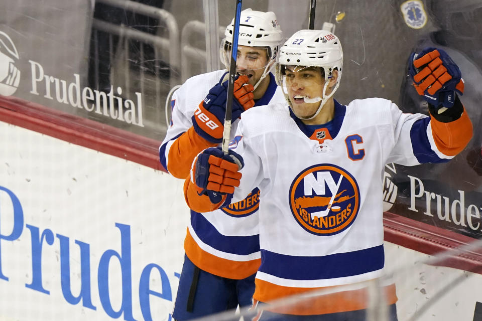 New York Islanders left wing Anders Lee, right, celebrates his game-winning goal during the third period of an NHL hockey game against the New Jersey Devils, Tuesday, March 2, 2021, in Newark, N.J. Islanders right wing Jordan Eberle (7) is at left. (AP Photo/Kathy Willens)