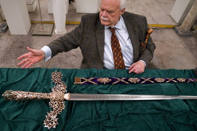 <p>Andrew Milligan/PA Images via Getty</p> Sword designer Mark Dennis views the new Elizabeth Sword to be used in King Charles' Scottish coronation celebration.