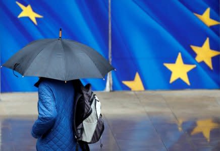 A man with an umbrella walks past the EU Commission headquarters in Brussels, Belgium November 12, 2018.  REUTERS/Francois Lenoir
