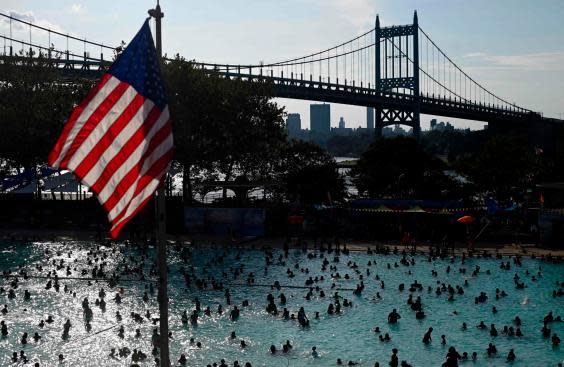 A US flag flies overhead as people enjoy the Astoria Pool on a hot afternoon in the New York City borough of Queens (AFP/Getty Images)