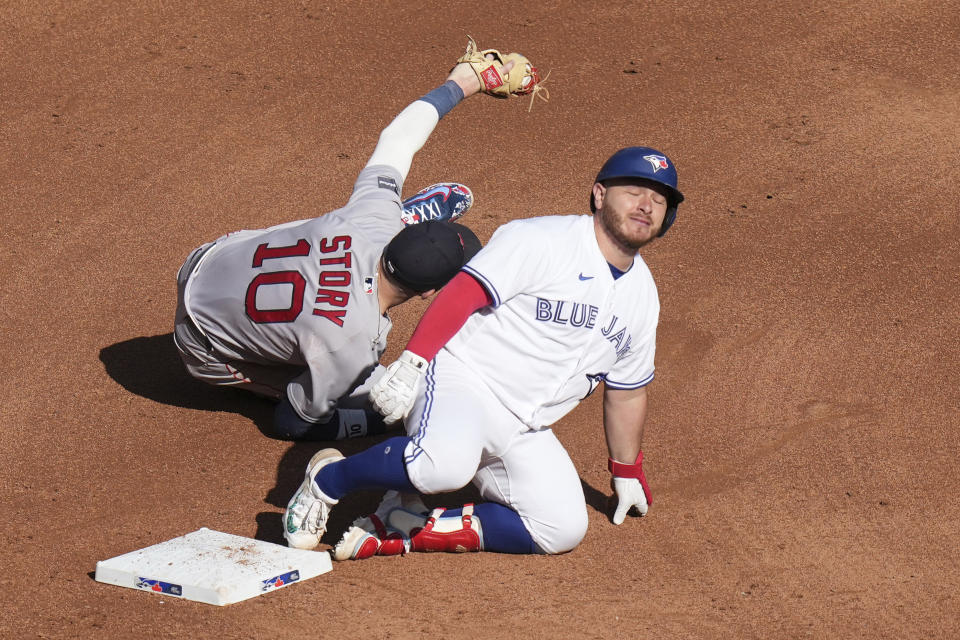 Toronto Blue Jays' Alejandro Kirk, right, reacts as he tagged out at second base by Boston Red Sox shortstop Trevor Story (10) after trying to stretch a single into a double during the fifth inning of a baseball game in Toronto, Saturday, Sept. 16, 2023. (Chris Young/The Canadian Press via AP)