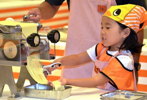 Children make instant noodles at the opening of a cup noodle museum in Yokohama, suburban Tokyo, on September 17. Japan's Nissin Foods opened a cup noodle museum charting the history of the speedy snack where visitors even get the chance to create their own tasty version