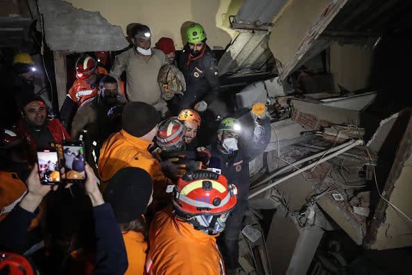 HATAY, TURKEY - FEBRUARY 09: Turkish and Mongolian rescue workers celebrate to survival of Hulya Kabakulak, 48-year-old survivor, at the site of a collapsed building after 90 hours on from the earthquake on  on February 09, 2023 in Hatay, Turkey. A 7.8-magnitude earthquake hit near Gaziantep, Turkey, in the early hours of Monday, followed by another 7.5-magnitude tremor just after midday. The quakes caused widespread destruction in southern Turkey and northern Syria and were felt in nearby countries. (Photo by Burak Kara/Getty Images)