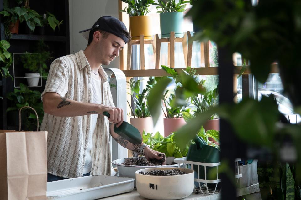 Plant House communications manager Patrick Tracy prepares pots for customers at Plant House inside of the Rust Belt Market in Ferndale on Friday, July 14, 2023.