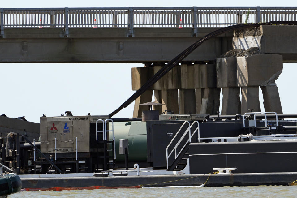 A section of railroad track hangs down from Pelican Island Bridge after a barge crashed into the bridge, Wednesday, May 15, 2024, in Galveston, Texas. (AP Photo/David J. Phillip)