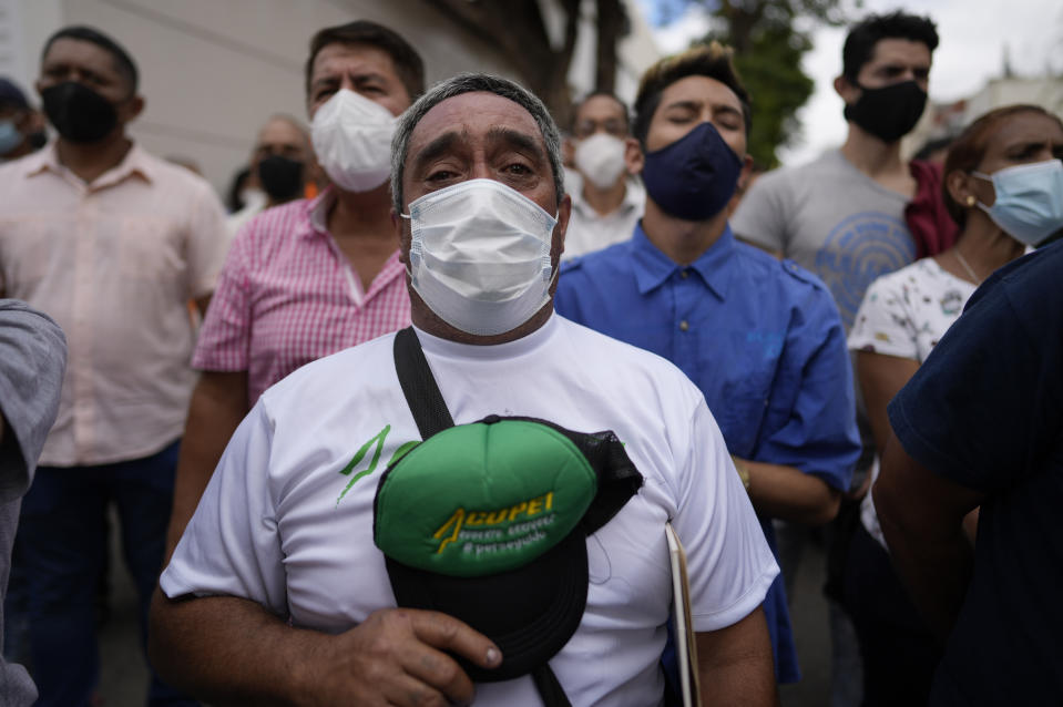 Residents stand for the national anthem as they gather with opposition members to mark Youth Day, in Caracas, Venezuela, Saturday, Feb. 12, 2022. The annual holiday commemorates youths who accompanied heroes in the battle for Venezuela's independence. (AP Photo/Ariana Cubillos)