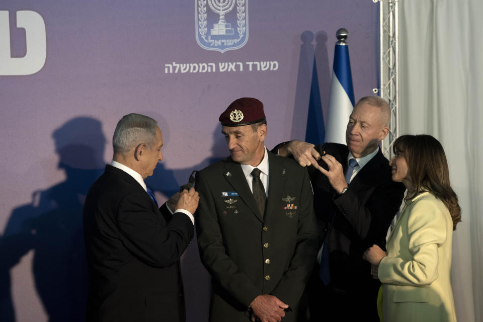 Sharon Halevi, right, watches as Israeli Prime Minister Benjamin Netanyahu, left, and Defense Minister Yoav Gallant, second right, promote her husband, the new Israel Defense Forces Chief of Staff Herzi Halevi to the rank of Lieutenant-General in Jerusalem, Monday, Jan. 16, 2023. (AP Photo/ Maya Alleruzzo, Pool)