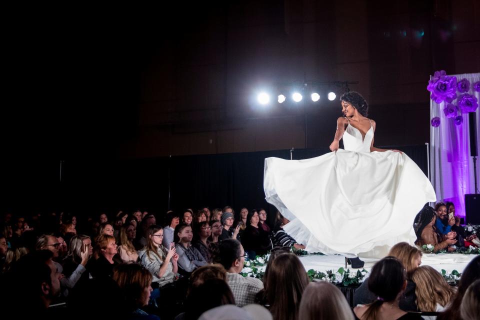 A model twirls in a wedding dress for the fashion show at the Wendy's Bridal Show in 2019.