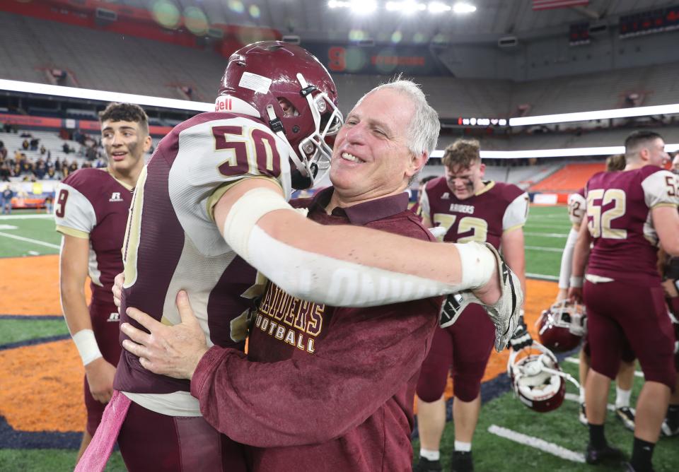 O'Neill coach David Moskowitz hugs his players after defeating General Brown to win the state Class C football championships at JMA Wireless Dome in Syracuse Dec. 3, 2022. 