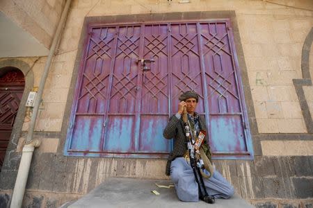 A follower of the Shi'ite Houthi movement sits near a house in Sanaa September 19, 2014. REUTERS/Khaled Abdullah