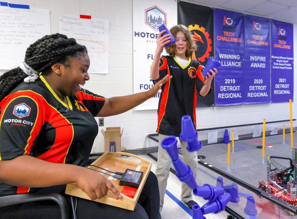 Robotics team members Tyneisha Powell, 13, left, and Joshua Baker, 11, have fun with staking cones during a break in practice at Detroit's Foreign Language Immersion And Cultural Studies School on Friday, Feb. 10, 2023. The team qualified for the world robotics championship that happens in Houston in April. It is the first Detroit middle school to compete in it.