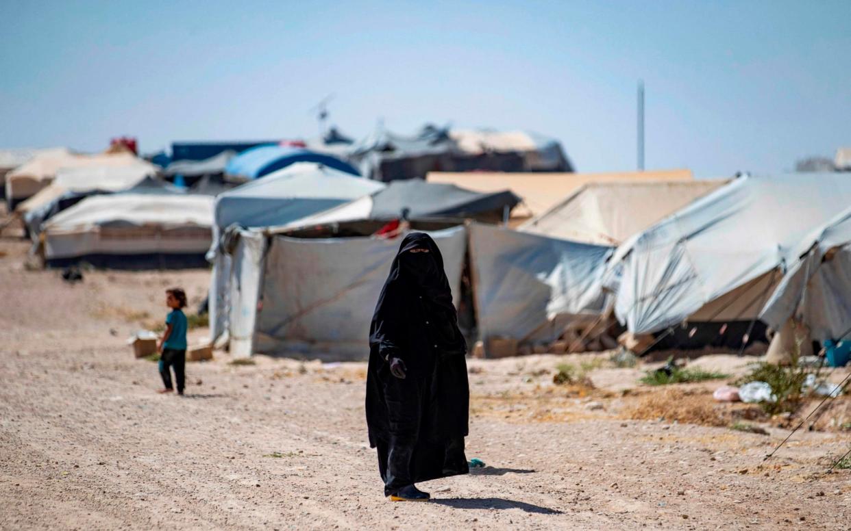 A woman walks in the Kurdish-run al-Hol camp in the al-Hasakeh governorate in northeastern Syria on August 25, 2020, where families of Islamic State (IS) foreign fighters are held.