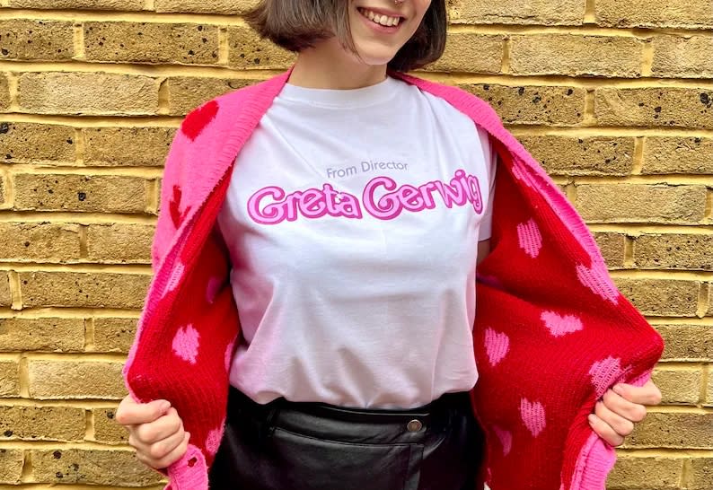 model wearing white shirt that reads "from director Greta Gerwig"