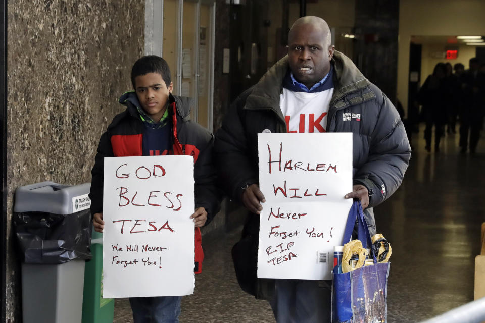 Calvin Hunt, right, and Cameron Hunt, 13, from the Harlem neighborhood of New York, leave court, Wednesday, Feb. 19, 2020, in New York. The pair attended the court appearance of Rashaun Weaver, who was charged with second-degree murder and robbery in the December attack on 18-year-old Tessa Majors, a Barnard College student. (AP Photo/Richard Drew)