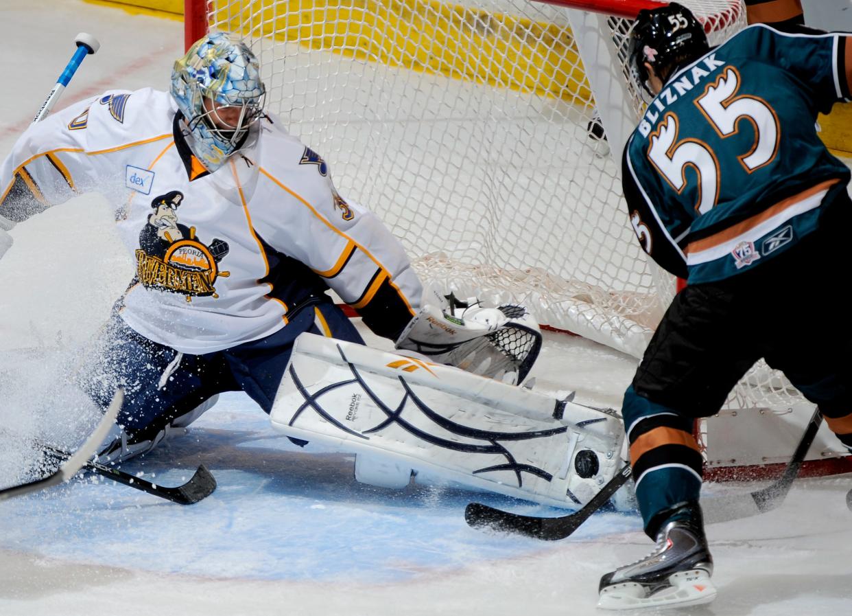 Mario Bliznak of the Manitoba Moose tries to score on goalie Ben Bishop of the Peoria Rivermen during a AHL-era game at Carver Arena.