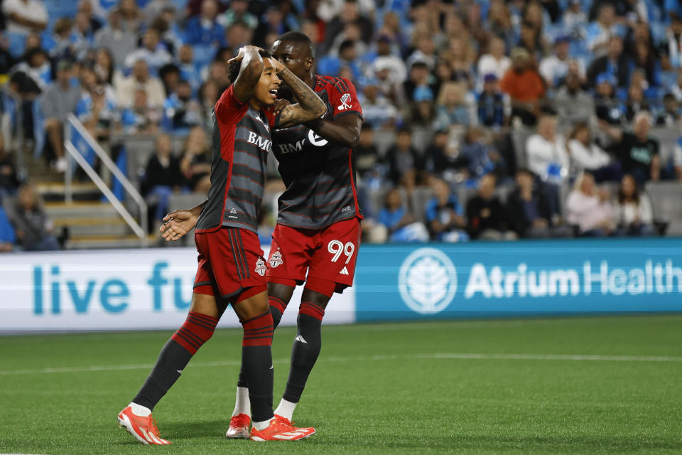 Toronto FC midfielder Jahkeele Marshall-Rutty, left, reacts to a missed shot as he is embraced by forward Prince Osei Owusu (99) during the second half of the team's MLS soccer match against Charlotte FC in Charlotte, N.C., Saturday, April 13, 2024. (AP Photo/Nell Redmond)