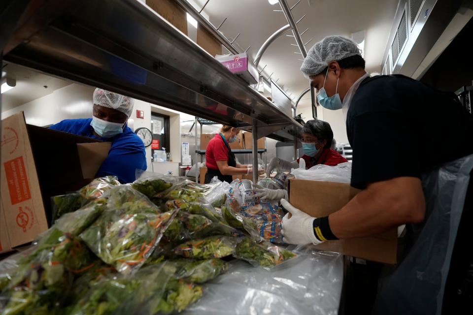 Los Angeles Unified School District food service workers from left, April Thomas, Marisel Dominguez, Tomoko Cho, and Aldrin Agrabantes pre-package hundreds of free school lunches in plastic bags on Thursday, July 15, 2021, at the Liechty Middle School in Los Angeles.