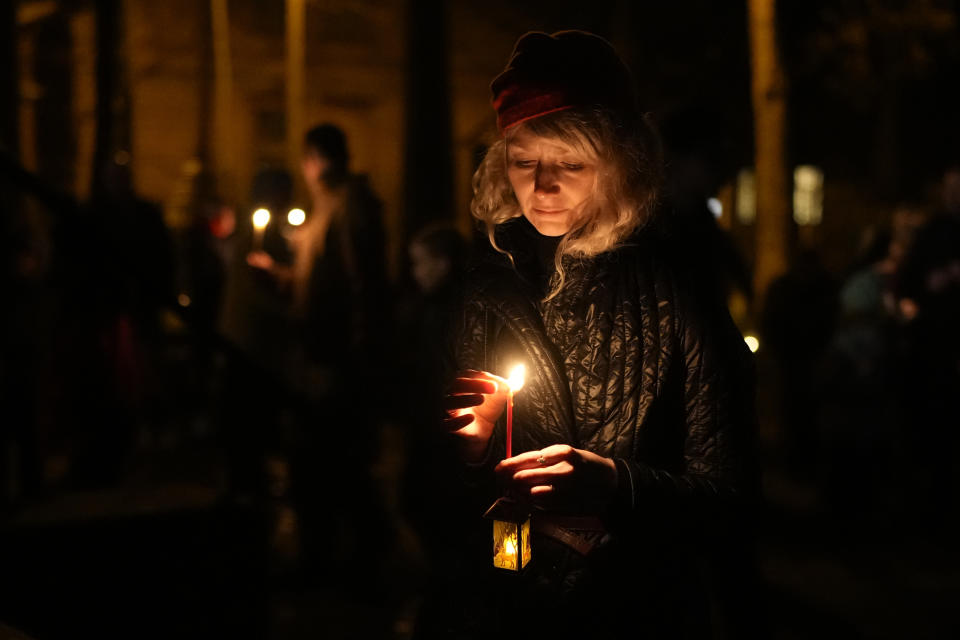 An Orthodox believer puts out her candle after Orthodox Easter midnight service at a church in St. Petersburg, Russia, Sunday, May 5, 2024. Eastern Orthodox churches observe the ancient Julian calendar and this year celebrate Orthodox Easter on May 5. (AP Photo/Dmitri Lovetsky)