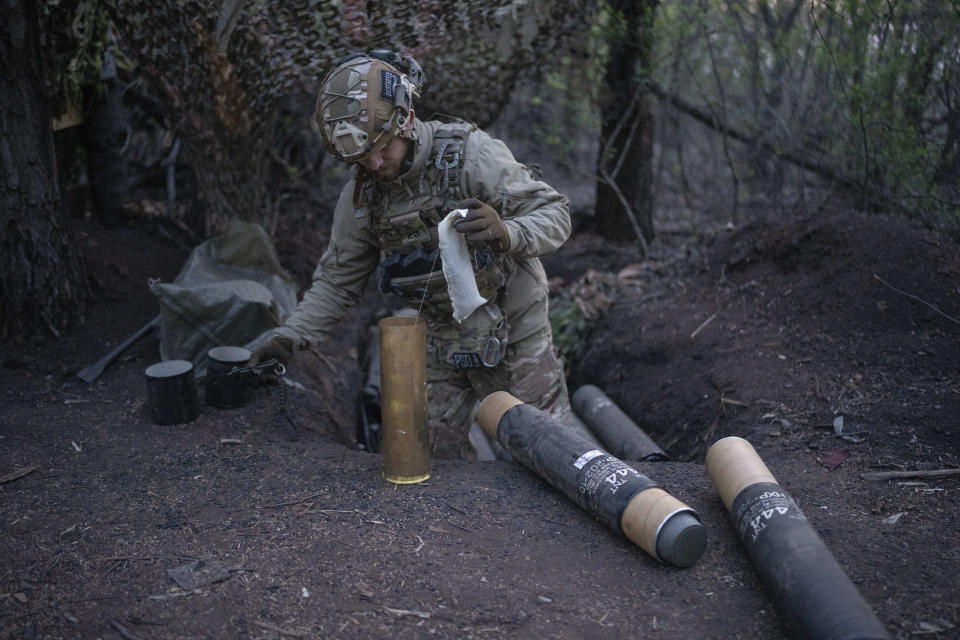 A Ukrainian serviceman from Azov brigade known by call sign Ray, 20, prepares shells for the OTO Melara Mod 56 howitzer on the frontline in Kreminna direction, Donetsk region, Ukraine, Thursday, April 11, 2024. (AP Photo/Alex Babenko)