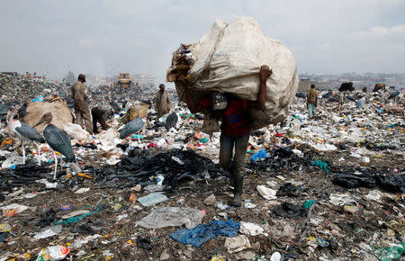 A scavenger carries recyclable plastic materials packed in a sack at the Dandora dumping site on the outskirts of Nairobi, Kenya August 25, 2017. REUTERS/Thomas Mukoya