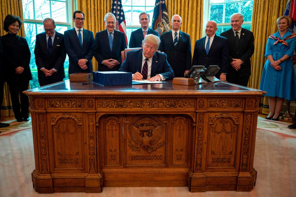 President Donald Trump signs the CARES Act on March 27, 2020.