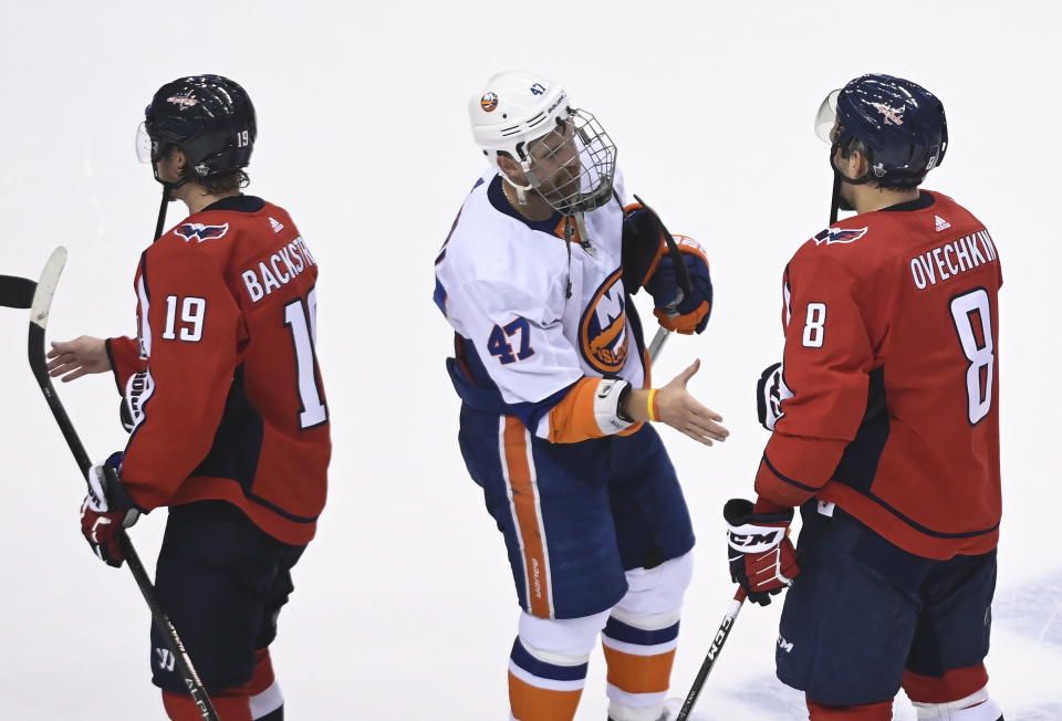 Washington Capitals left wing Alex Ovechkin (8) shakes hands with New York Islanders right wing Leo Komarov (47) after an NHL Stanley Cup playoff hockey game in Toronto on Thursday, Aug. 20, 2020. (Nathan Denette/The Canadian Press via AP)