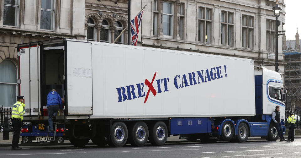 A policeman escorts the driver of a shellfish export truck as he is stopped for an unnecessary journey in London, Monday, Jan. 18, 2021, during a demonstration by British Shellfish exporters to protest Brexit-related red tape they claim is suffocating their business. The drivers were later stopped by police and issued with fines for an 'unnecessary journey' due to the national lockdown to curb the spread of the coronavirus. (AP Photo/Alastair Grant)