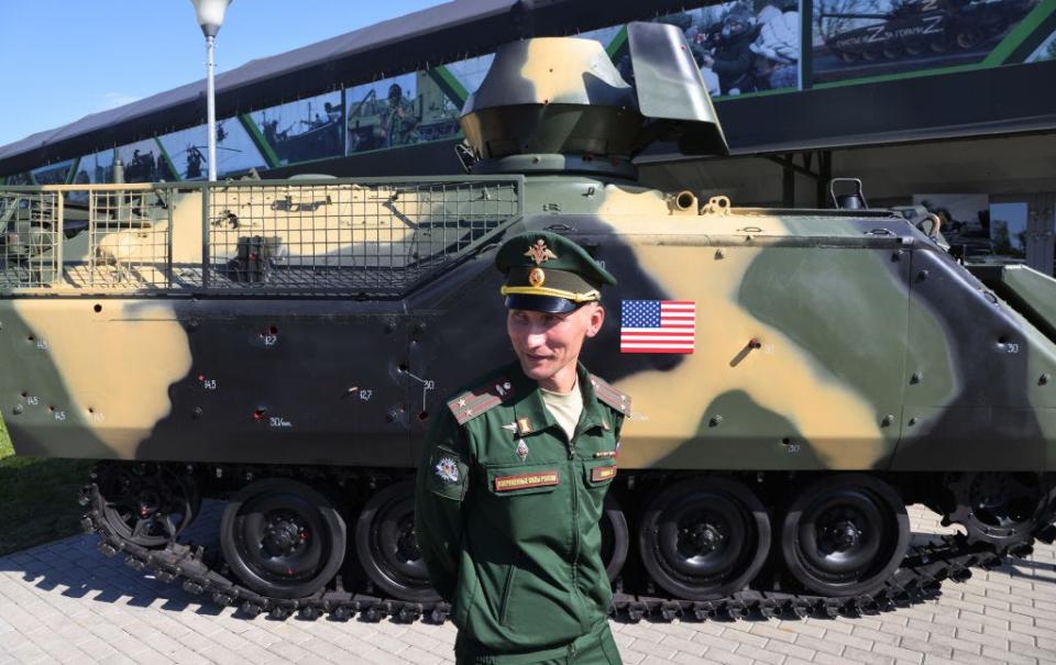 A Russian army colonel smiles near a Vehicle M-113, made in USA and captured in Ukraine in 2023, during a propaganda exhibition of captured Ukrainian weapons, on August 15, 2023 in Kubinka, Russia.