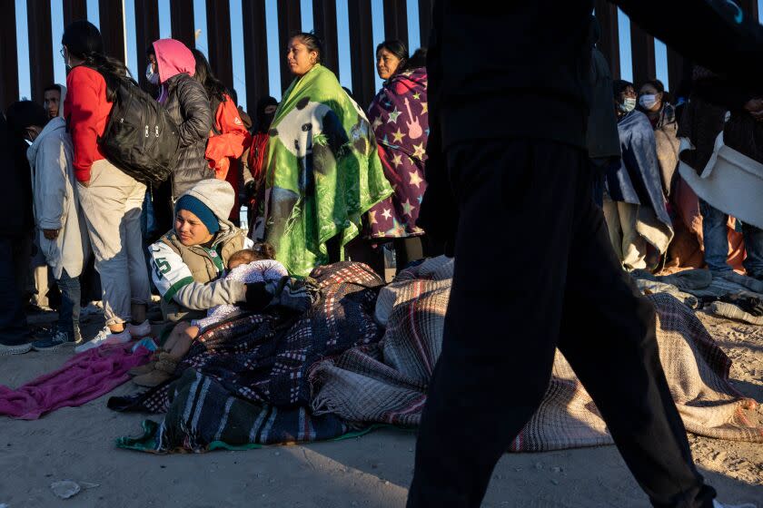 EL PASO, TEXAS - DECEMBER 22: Immigrants bundle up against the cold after spending the night camped alongside the U.S.-Mexico border fence on December 22, 2022 in El Paso, Texas. A spike in the number of migrants seeking asylum in the United States has challenged local, state and federal authorities. The numbers are expected to increase as the fate of the Title 42 authority to expel migrants remains in limbo pending a Supreme Court decision expected after Christmas. (Photo by John Moore/Getty Images)