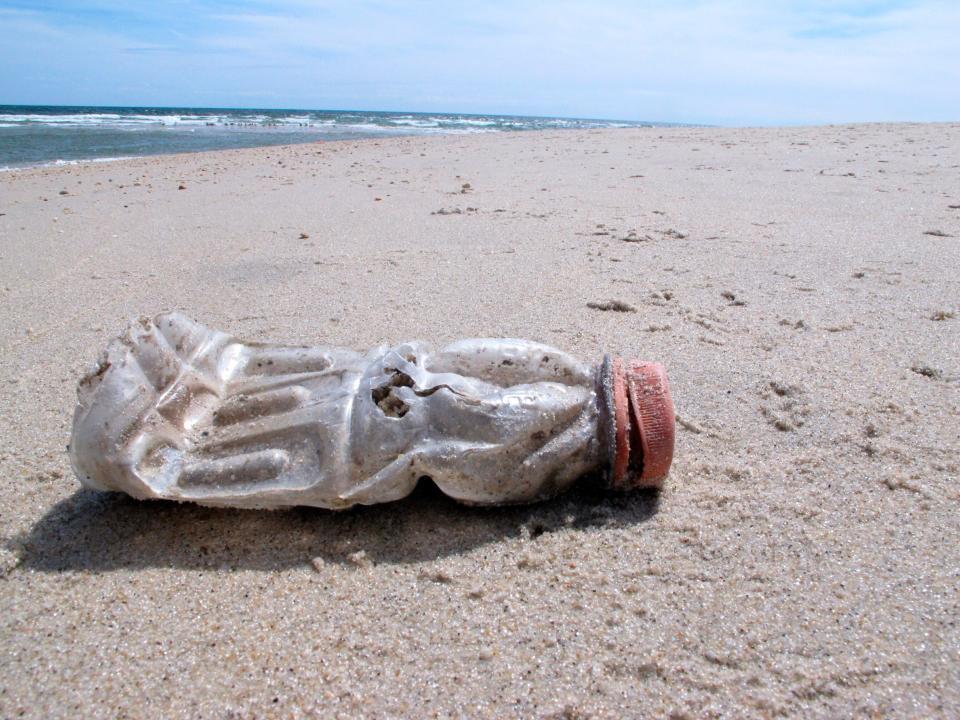 A discarded plastic bottle lies on the beach at Sandy Hook, N.J. on Tuesday, April 2, 2019.