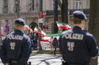 FILE - In this April 9, 2021 file photo, protesters with the Lion and Sun flag of the National Council of Resistance of Iran, an Iranian opposition group, and police officers stand near the 'Grand Hotel Wien' in Vienna, Austria, where closed-door nuclear talks with Iran take place. Negotiations to bring the United States back into a landmark nuclear deal with Iran are set to resume Thursday, April 15, in Vienna amid signs of progress — but also under the shadow of an attack this week on Iran's main nuclear facility. (AP Photo/Florian Schroetter, File)