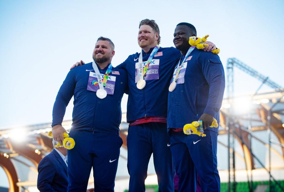 Gold medalist Ryan Crouser, center, stands on the podium with silver medalist Joe Kovacs, left, and bronze medalist Josh Awotunde, all athletes from the United States, during the Sunday medal ceremony for the men's shot put.