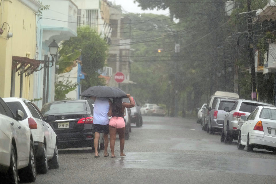 Unas personas caminan bajo la lluvia provocada por la tormenta tropical Franklin en Santo Domingo, República Dominicana, el miércoles 23 de agosto de 2023. (AP Foto/Ricardo Hernandez)