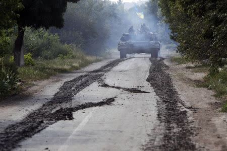 A Ukrainian tank moves along a road near Eastern Ukrainian village of Novoselivka Persha July 31, 2014. REUTERS/Valentyn Ogirenko