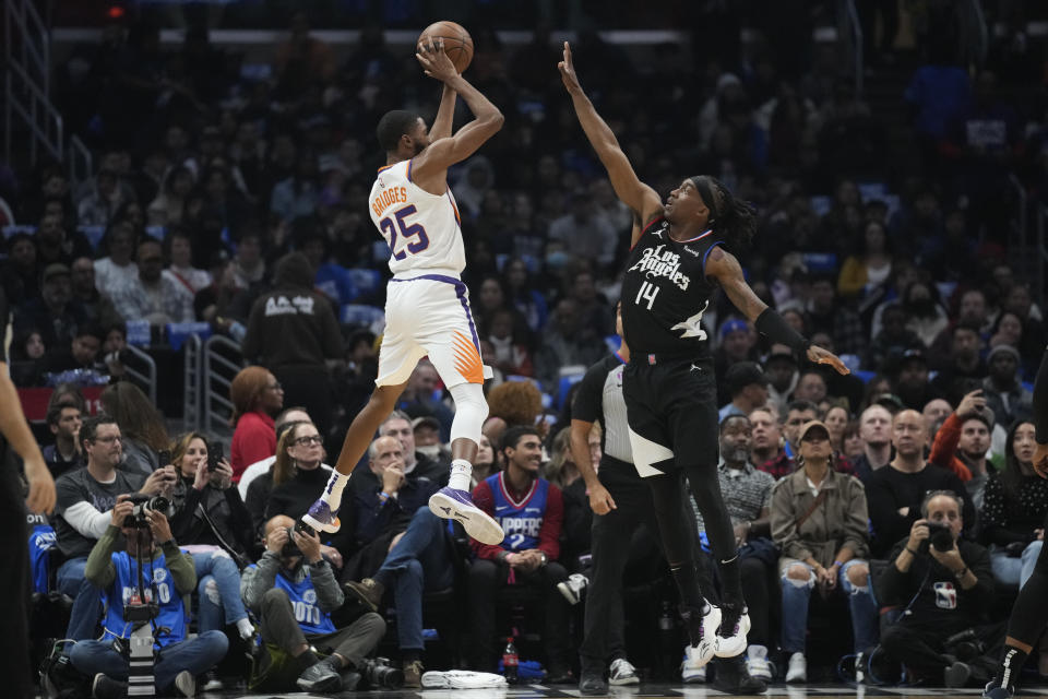 Phoenix Suns forward Mikal Bridges (25) shoots against LA Clippers guard Terance Mann (14) during the first half of an NBA basketball game in Los Angeles, Thursday, Dec. 15, 2022. (AP Photo/Ashley Landis)