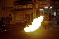 Firefighters work to extinguish a fire during a protest in Madrid November 4, 2013. Spain's labor unions called for an indefinite strike from Tuesday in Spain's capital for the street cleaning and park maintenance sectors in protest against announced layoffs that could affect around a thousand municipal workers, according to local media. (REUTERS/Juan Medina)