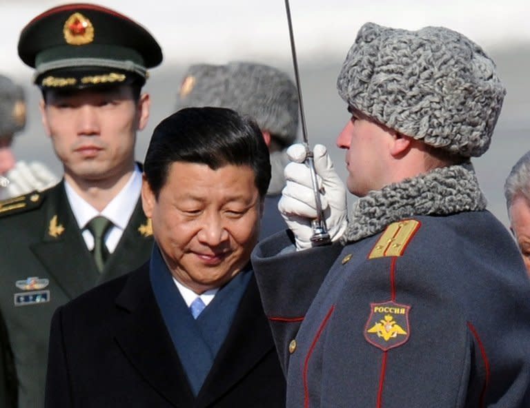 Chinese President Xi Jinping (C) reviews a guard of honour on arrival at Vnukovo airport outside Moscow on March 22, 2013. Xi, who arrived in Russia accompanied by first lady Peng Liyuan, said he was eager to boost "strategic cooperation" with Vladimir Putin, stressing his personal rapport with the Russian strongman