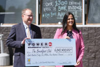 Attorney Mark K. Harder, left, representative of The Breakfast Club, and Michigan Lottery Commissioner Suzanna Shkreli hold an an enlarged check for the $842.4 million Powerball jackpot, from the Jan. 1, 2024 drawing, at a news conference at Food Castle in Grand Blanc Township, Mich., Tuesday, June 11, 2024. (AP Photo/Paul Sancya)