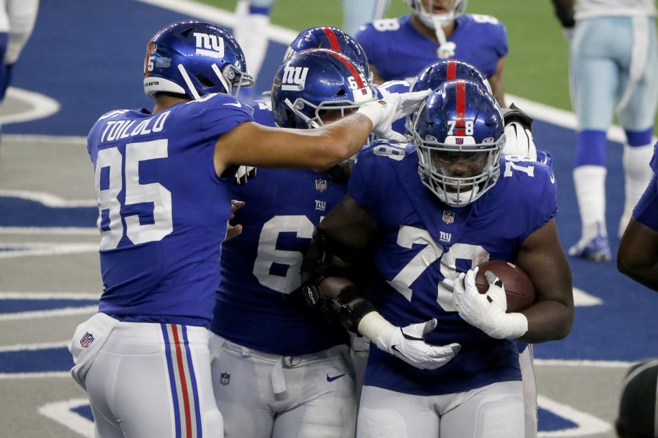 New York Giants tight end Levine Toilolo (85) and Nick Gates (65) celebrate with Andrew Thomas (78) who caught a pass for a two-point conversion in the second half of an NFL football game against the Dallas Cowboys in Arlington, Texas, Sunday, Oct. 11, 2020. (AP Photo/Michael Ainsworth)