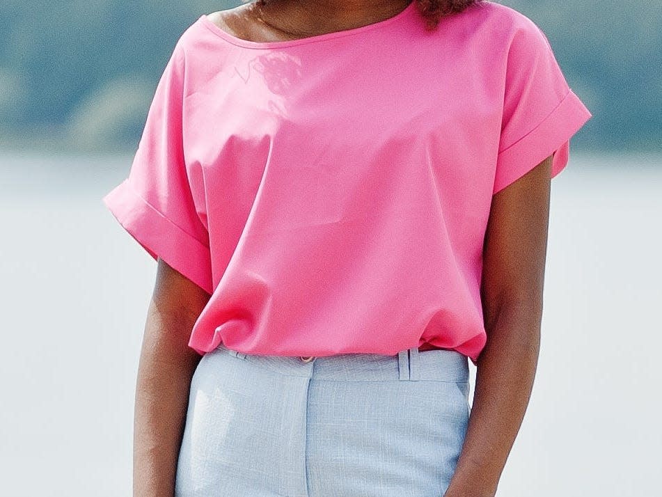 Woman wearing pink blouse and jeans.