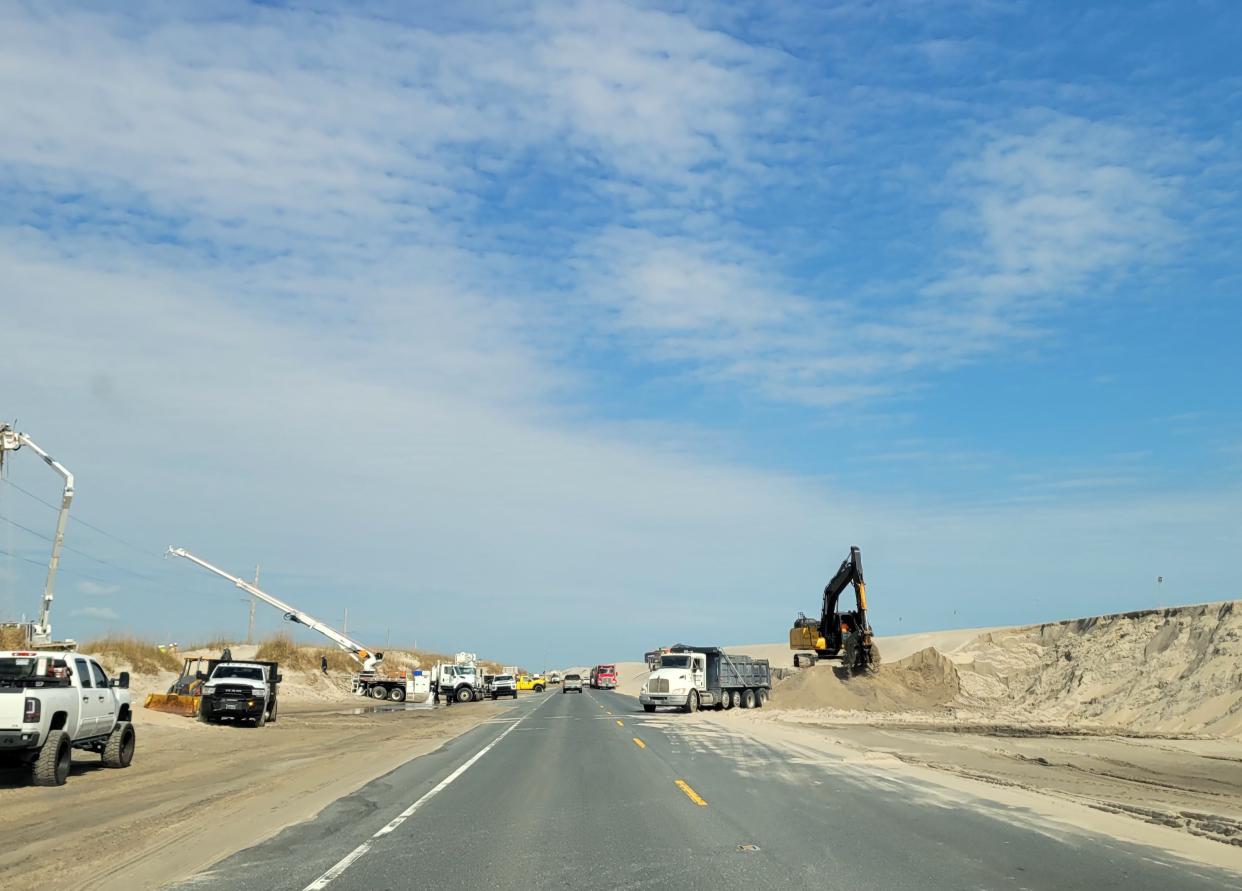 Construction workers build a sand dune along North Carolina Highway 12, the oceanfront highway along the Outer Banks, to protect the road from high tides and waves that wash over the road.