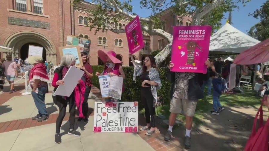 Protestors at USC hold up signs calling for a ceasefire in Gaza. and to support USC valedictorian Asna Tabassum during a demonstration held at USC on April 21, 2024. (KTLA)