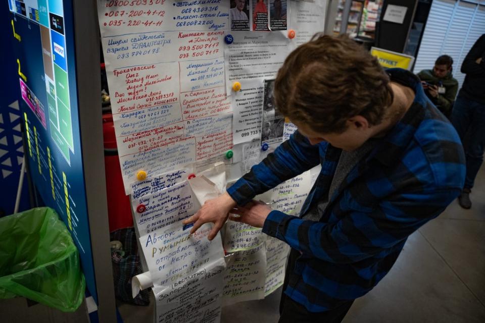 A volunteer goes through the messages families have posted about their missing relatives in Mariupol (Bel Trew)