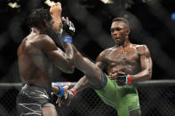 Israel Adesanya, right, kicks Jared Cannonier in a middleweight title bout during the UFC 276 mixed martial arts event Saturday, July 2, 2022, in Las Vegas. (AP Photo/John Locher)