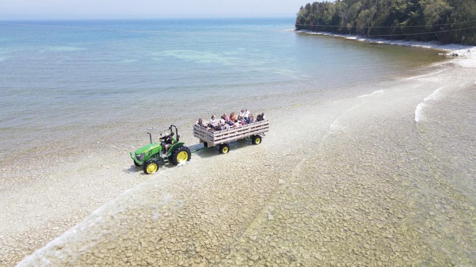 A tractor takes people across the causeway that connects the mainland to the 150-year-old 89-foot  tall Cana Island Lighthouse in Baileys Harbor in Door County on Sunday, May 23, 2021. DRONE - Photo by Mike De Sisti / Milwaukee Journal Sentinel via USA TODAY NETWORK