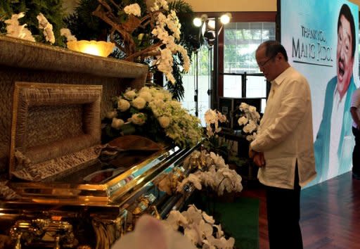 Philippine President Benigno Aquino offers prayers next to the casket of the late comedian Rodolfo Vera Quizon