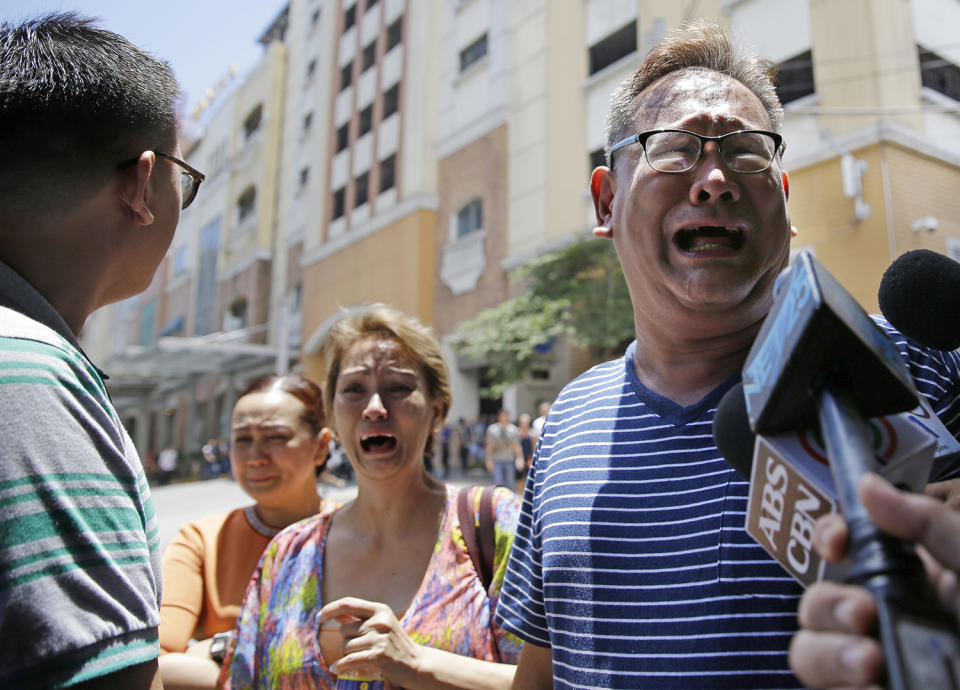 <p>A family grieves as they wait for their daughter's body at the Resorts World Manila complex, Friday, June 2, 2017, in Manila, Philippines. (Photo: Aaron Favila/AP) </p>