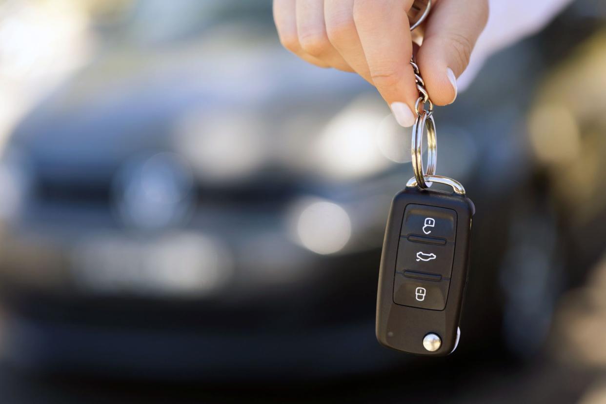 car keys held in hand, car in background